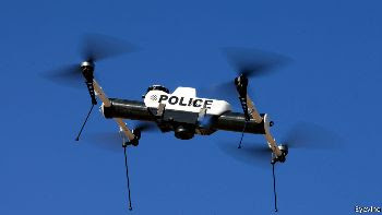 Drone that says Police on the side hovering in the air.